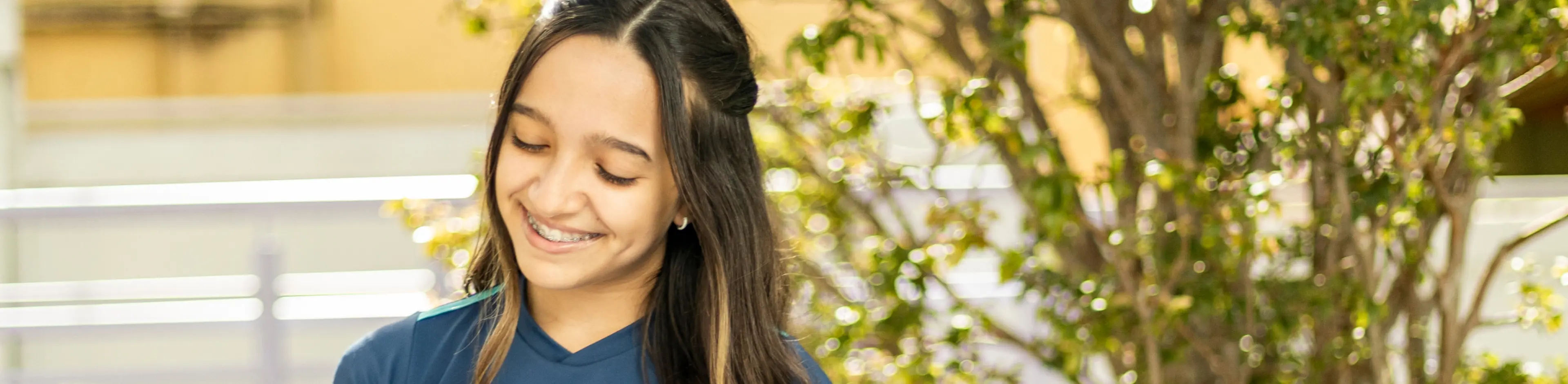 Aluna do Ensino Fundamental Anos finais estudando o Livro Didático de Bernoulli ao ar livre